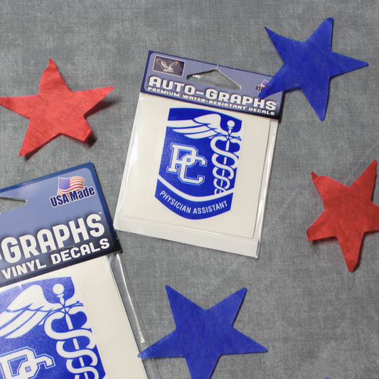 Picture that features the small PC Physician Assistant Decal. The decals are stylized as the PC PA badge and are royal blue with white details. The background of the photo has red and blue stars surrounding the decals.