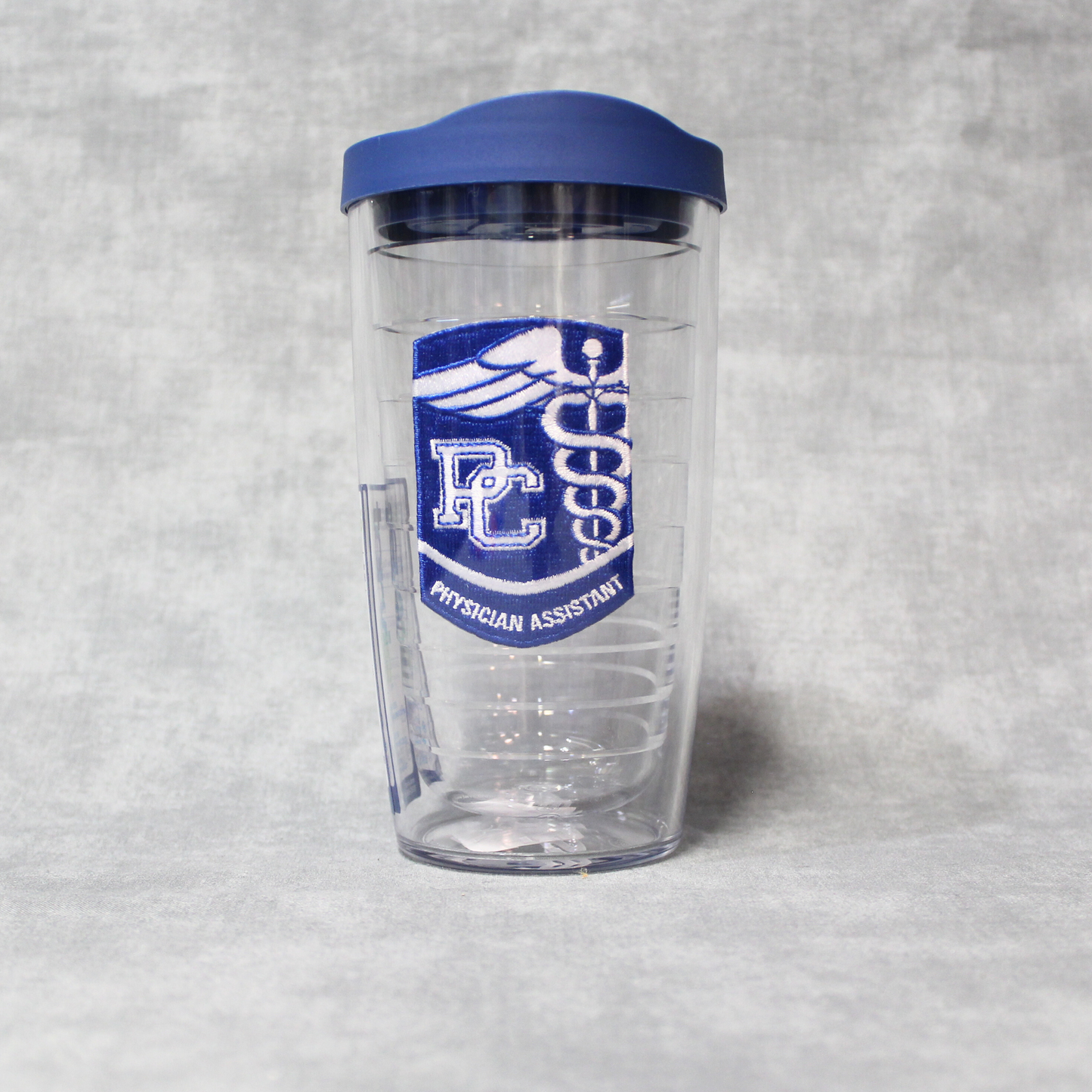 Product Photo of a 16 oz tervis tumbler with a royal and white PC Physician's Assistant Patch between the double walls.