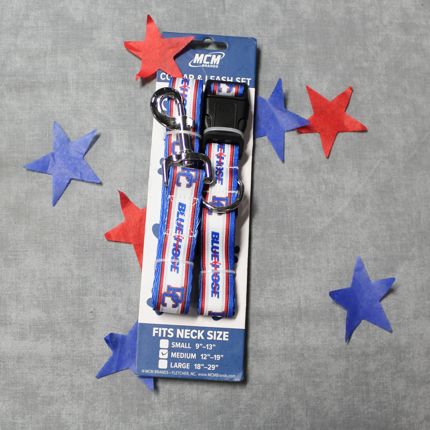 Photo of a pet leash and collar set that has the PC logo and Blue Hose wordmark on it. The background of this photo has red and blue stars behind/around the leash.