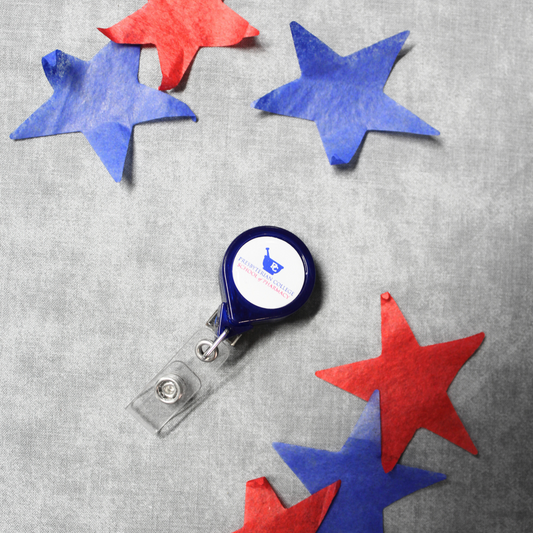 A photo of a retractable lanyard branded with the Presbyterian College School of Pharmacy logo. The background of this photo has several blue, and red stars surrounding the lanyard.