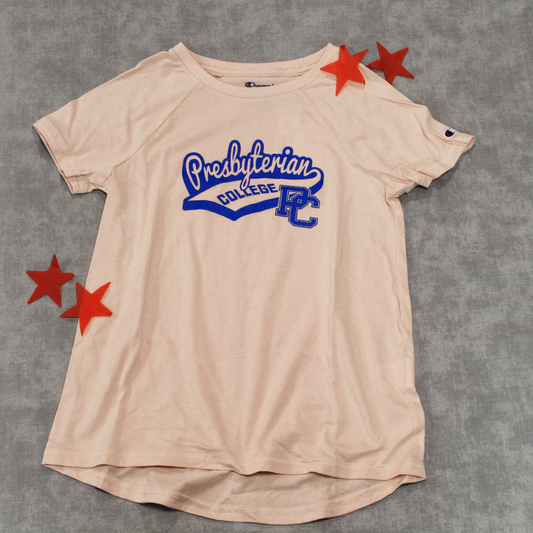 Full picture of the light pink raglan sleeve youth champion shirt. The design features 'Presbyterian' in a cursive font similar to a baseball shirt with "college" underneath it and a block PC logo. The whole graphic is printed in royal blue. In this photo there are 4 red stars framing the shirt.