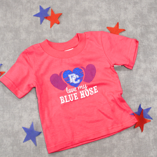 Hot pink infant t-shirt with a blue heart graphic and a white block PC logo on it with the words "love my blue hose" on it. This product photo has red and blue stars on/around the product.