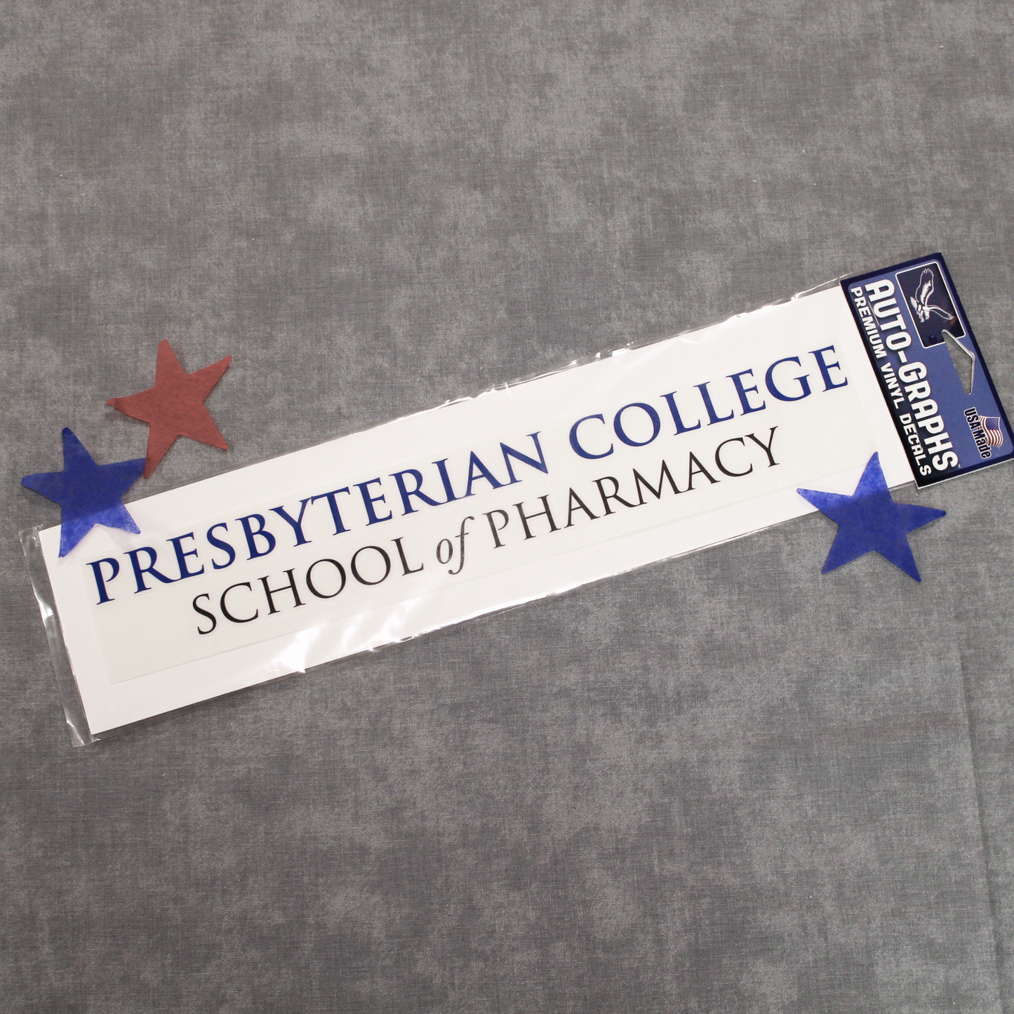A picture of a Presbyterian College School of Pharmacy decal. The background of the photo has some red and blue stars surrounding the decal.