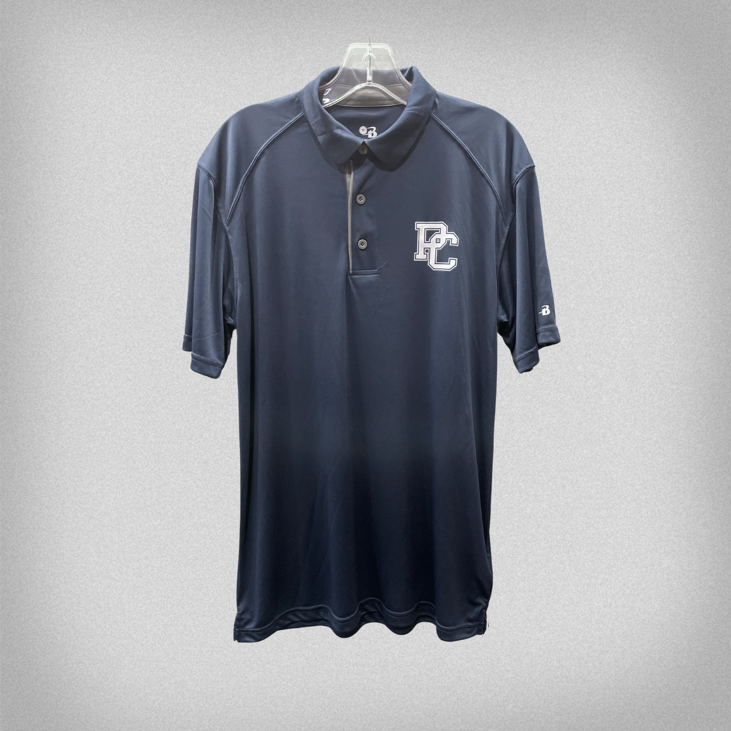 Product photo of a navy blue polo shirt from Badger that has a white block PC logo printed on the front left chest.