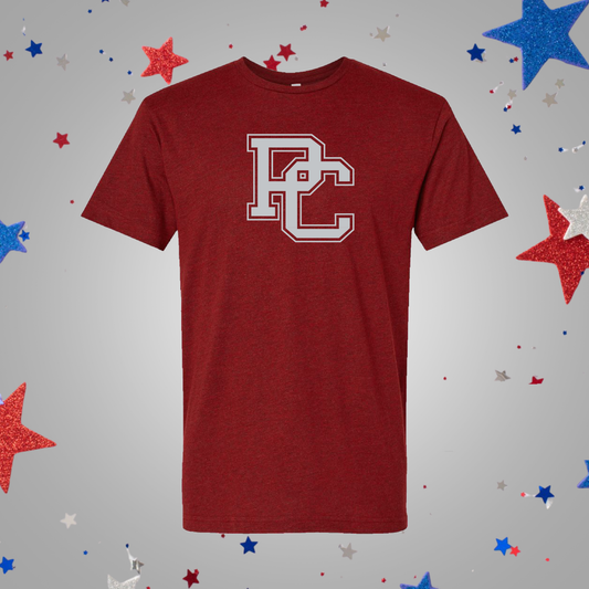 A garnet short-sleeve t-shirt with a light gray collegiate-style 'PC' logo on the chest, displayed against a neutral gray background with confetti red, white, and blue stars.