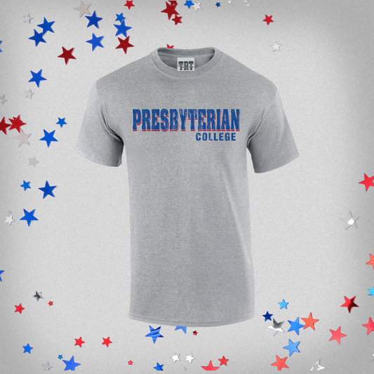Product photo of a light grey t-shirt has a royal and red distressed screen print graphic that says "Presbyterian College" The background of the product photo has red, white, and blue stars.