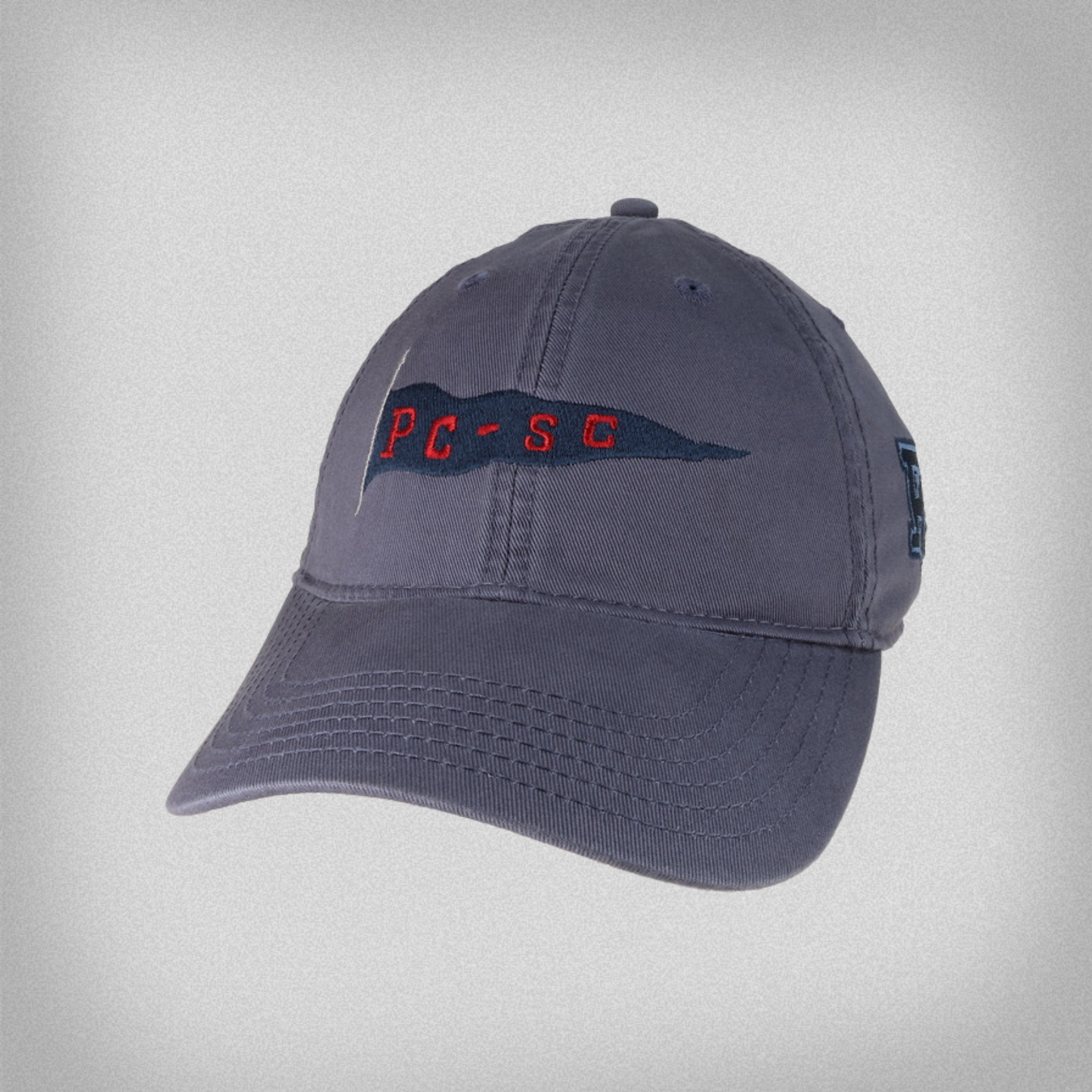 Slate Blue hat with an embroidered PC-SC pennant flag across the front of the hat, with a blue embroidered PC logo on the side.