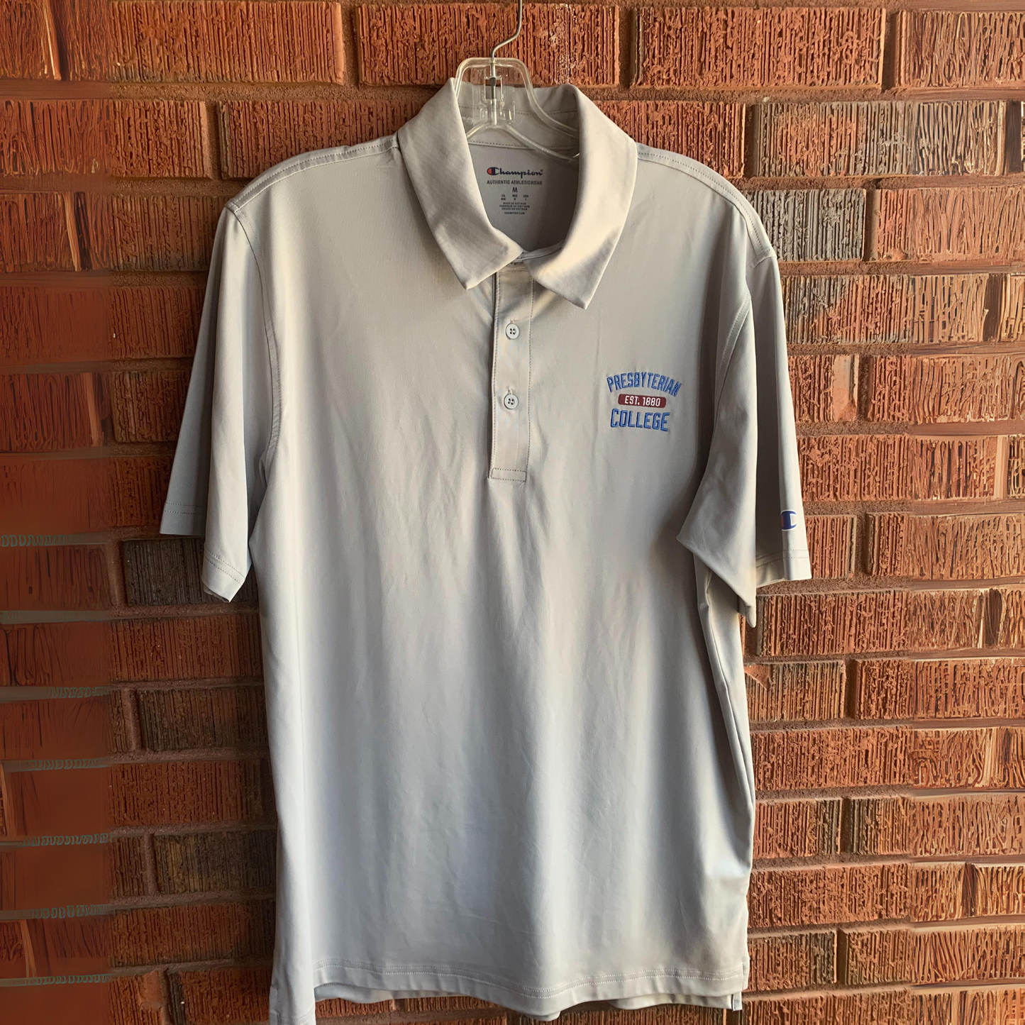 Light grey polo from Champion with Presbyterian College est 1880 embroidered in blue, red, and white.