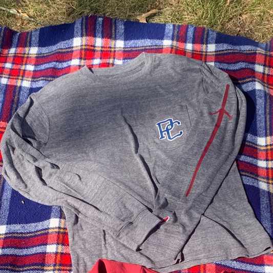 Another view of the grey long sleeve t shirt with a pocket printed with a 4 color block PC logo on the left front chest and a red broadsword printed down the left sleeve.