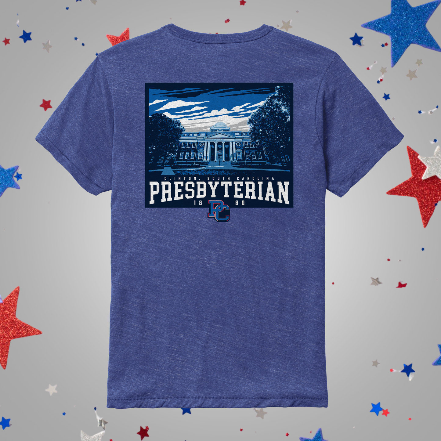 A heathered blue short-sleeve t-shirt shown from the back, featuring a large graphic print of a classical building with the text 'PRESBYTERIAN 1868' and a small blue 'PC' logo. The shirt is displayed on a light gray background decorated with scattered red, white, and blue glitter stars.