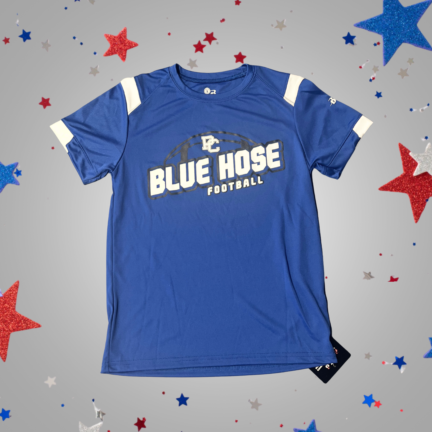A royal blue short-sleeve athletic t-shirt with 'BLUE HOSE FOOTBALL' printed in white and gray on the front, featuring white shoulder stripes, displayed on a gray background decorated with red, white, and blue glittery stars.