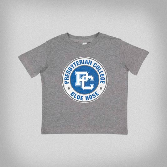 Product photo of a gray toddler t-shirt with a blue and white distressed Presbyterian College design on it. The product photo has a gray background.
