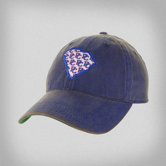 Blue baseball cap with a South Carolina State shaped patch with the block PC logo repeated over it.