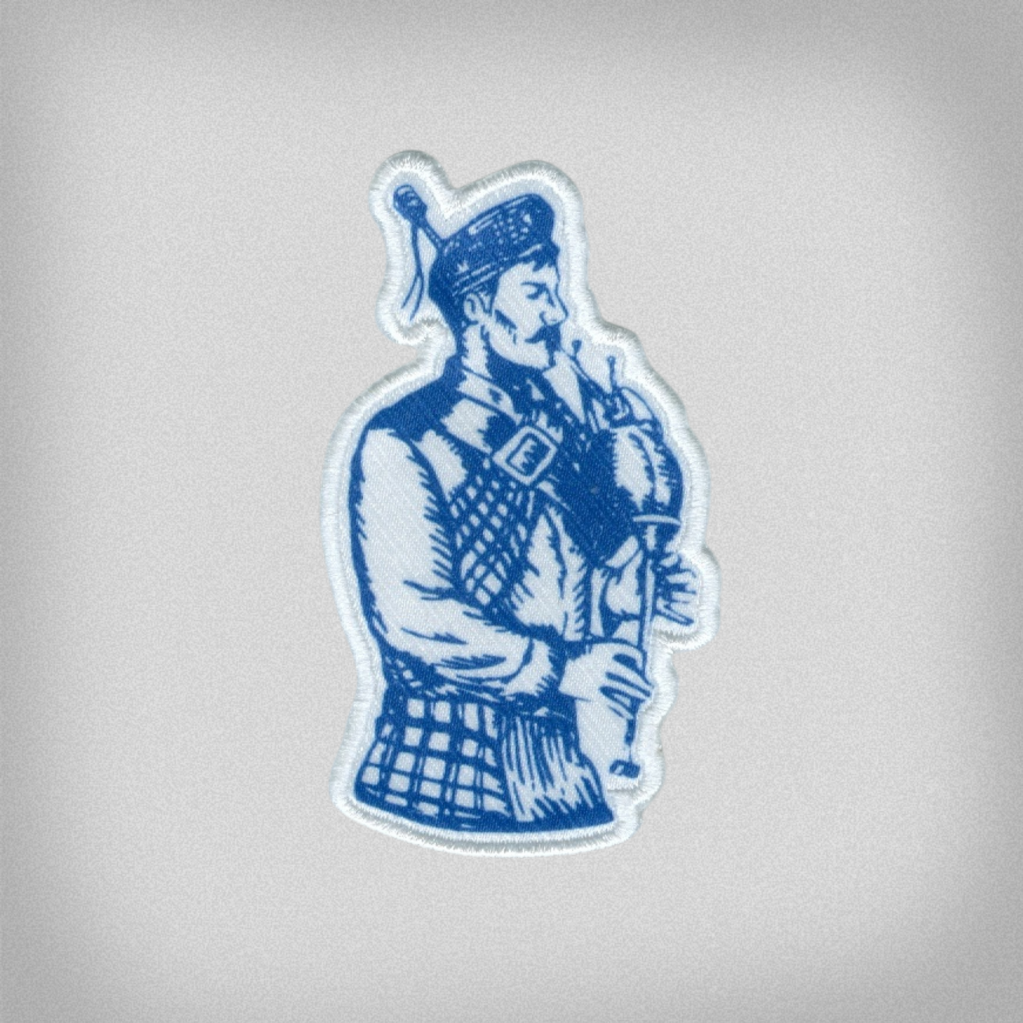 Blue and white patch of the Presbyterian College Bagpiper Scotsman