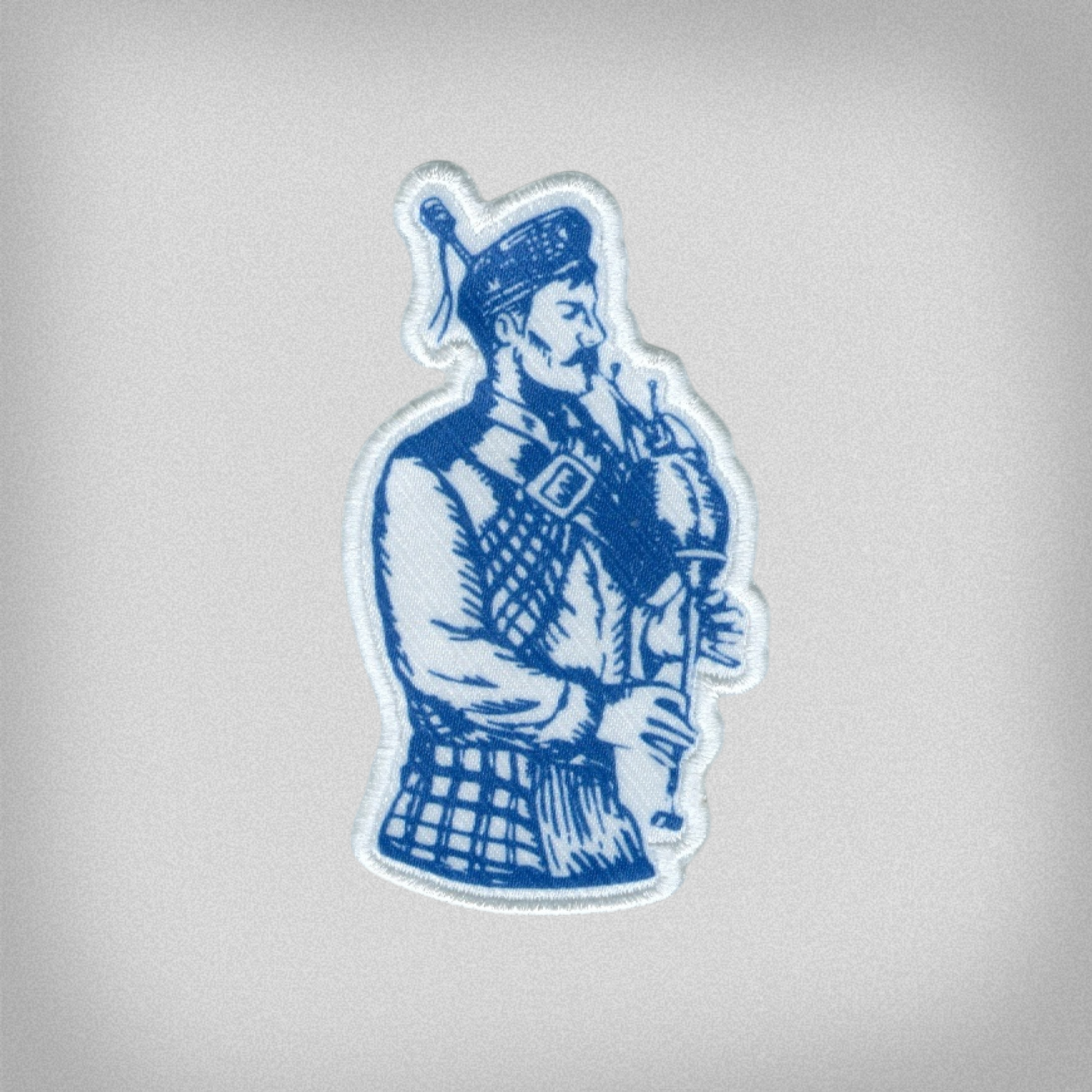 Blue and white patch of the Presbyterian College Bagpiper Scotsman